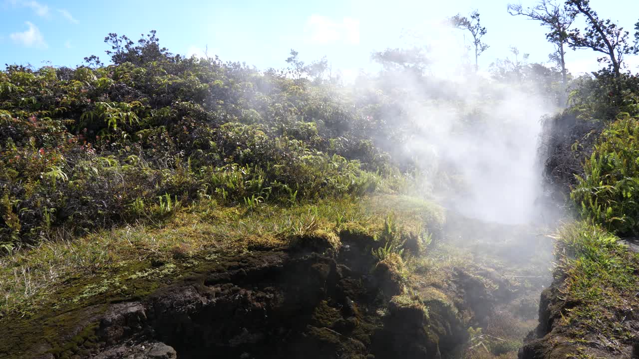 vistas de cerca de grietas en la tierra cerca del volcán kilauea en hawaii donde el vapor se escapa en un día soleado con algunas nubes