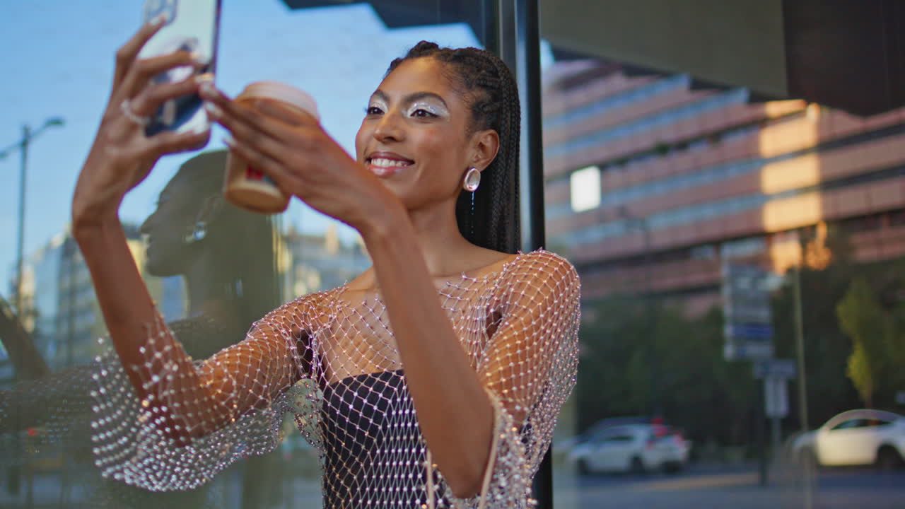 Longhair brunette taking self picture at urban glass wall background closeup
