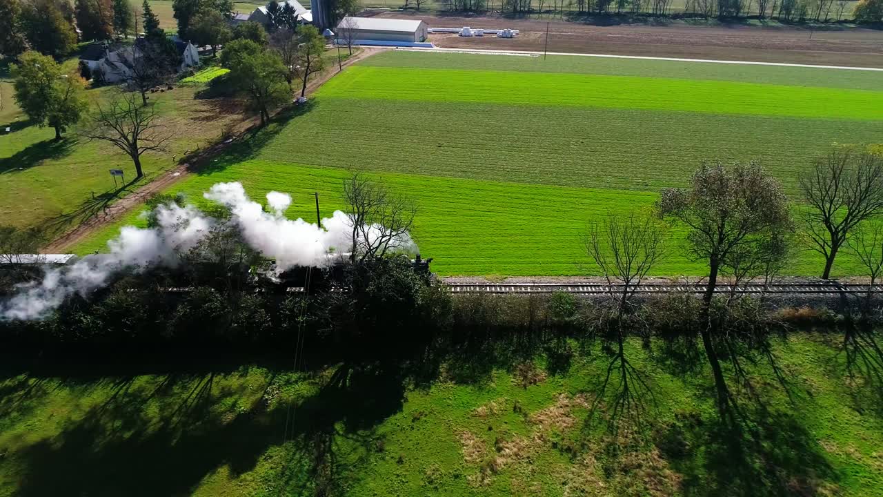 드론으로 본 아미쉬 시골을 따라 연기를 내뿜는 증기 여객 열차