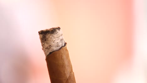 extreme close up of someone holding and smoking a cigar in the caribbean