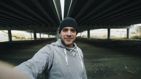 man taking selfie under an underpass