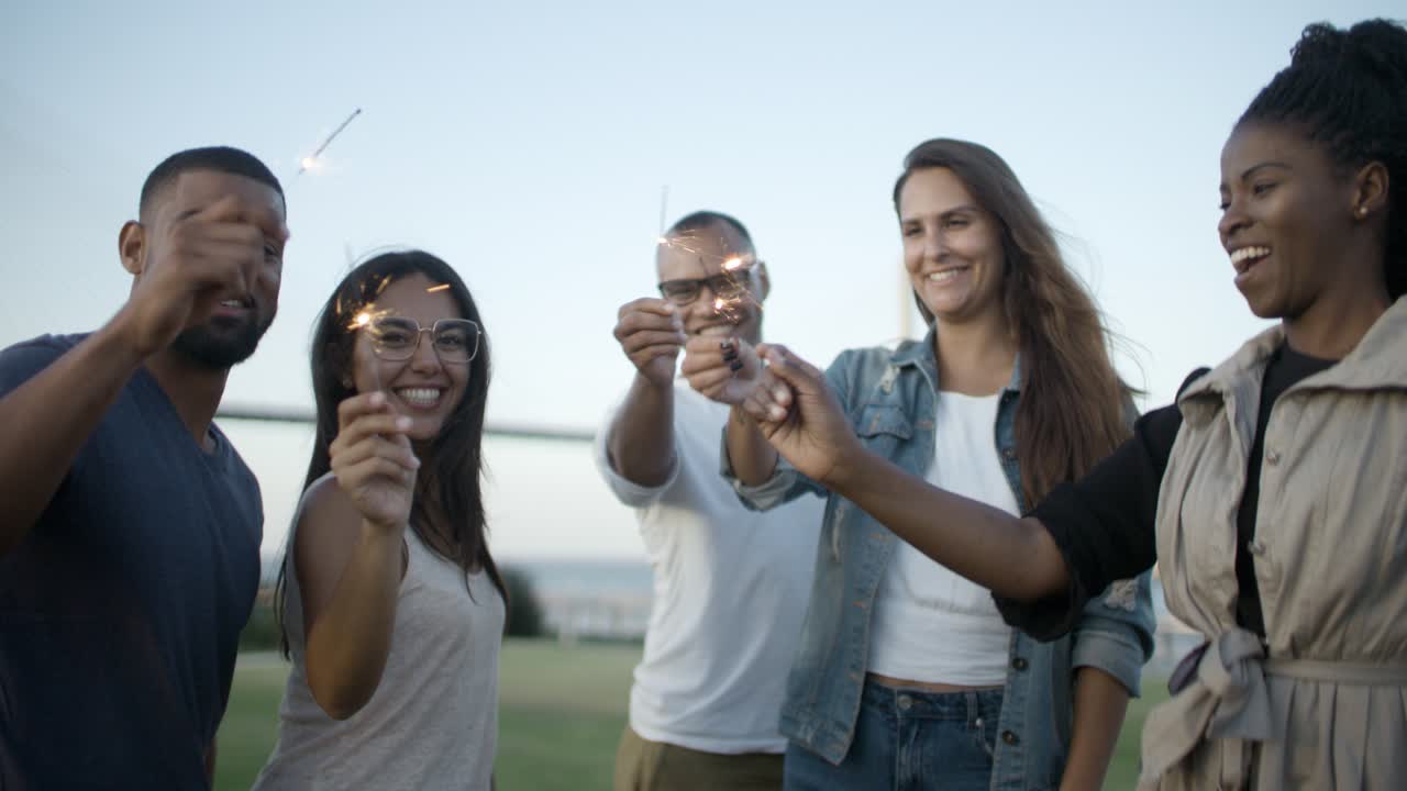 Amici felici che posano con le stelline luminose nel parco