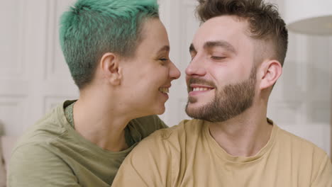 portrait of a loving couple cuddling sitting on the bed at home