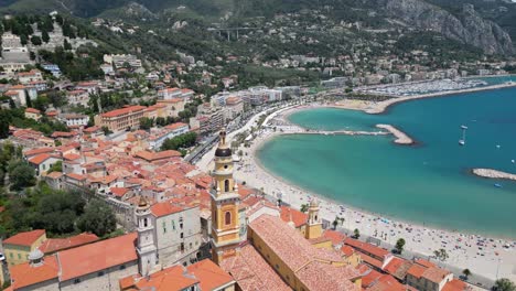 Saint-Michel-Basilica-and-Marina-at-the-seaside-town-of-Menton-Southern-France,-Aerial-orbit-shot