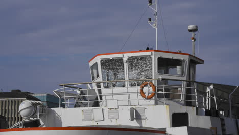 a boat docked, the reflection of the river in it's windows