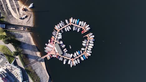 leisure ships, sailing boats and motor yachts in a circular pattern docked at the harbor. aerial top down drone video