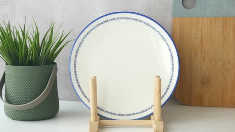 white plate with blue border on a wooden plate stand