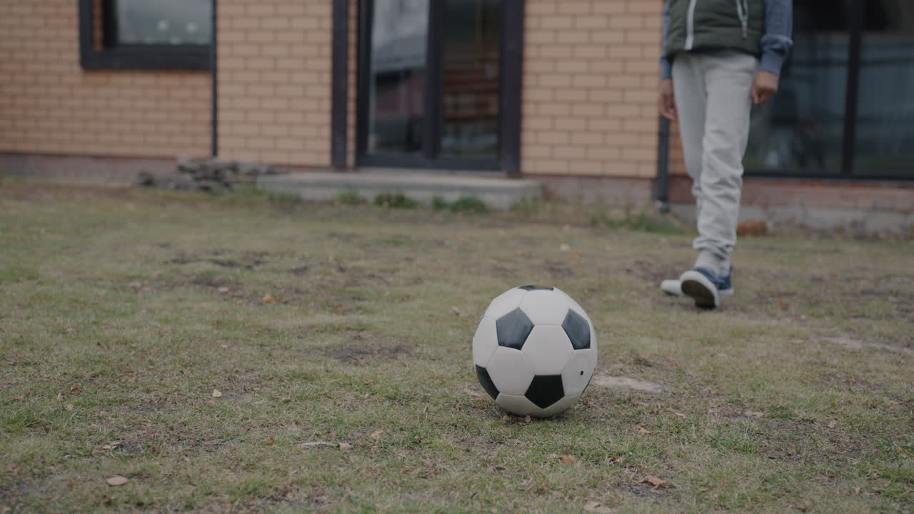 Child playing soccer in backyard