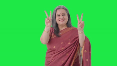 happy indian old woman showing victory sign green screen