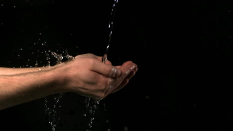 running water falling on mans hands