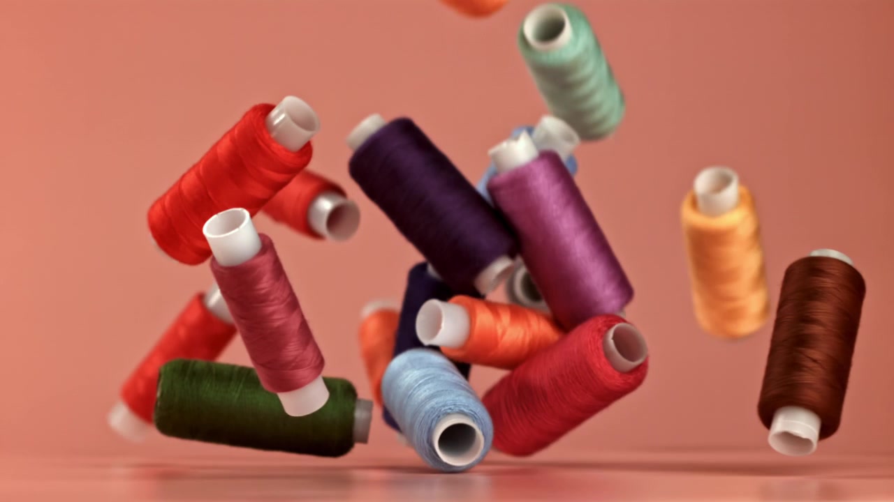 Colorful Spools of Thread Falling in Slow Motion