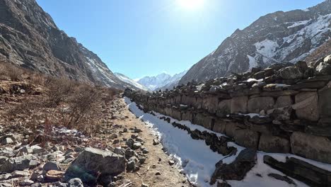 caminando a lo largo de las paredes de oración budista tibetana en un valle del himalaya de gran altitud