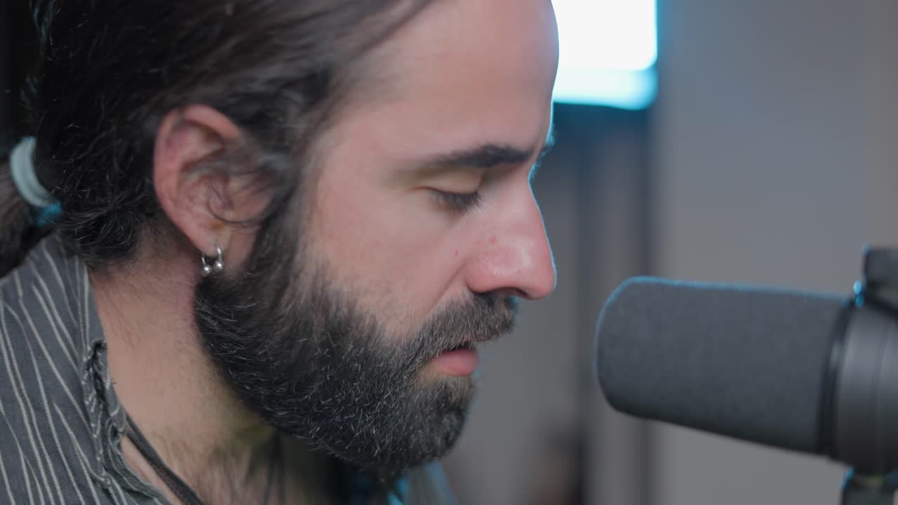hombre cantando en el micrófono en el estudio