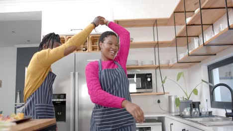 Feliz-Pareja-Afroamericana-En-Delantales-Bailando-En-La-Cocina,-Cámara-Lenta