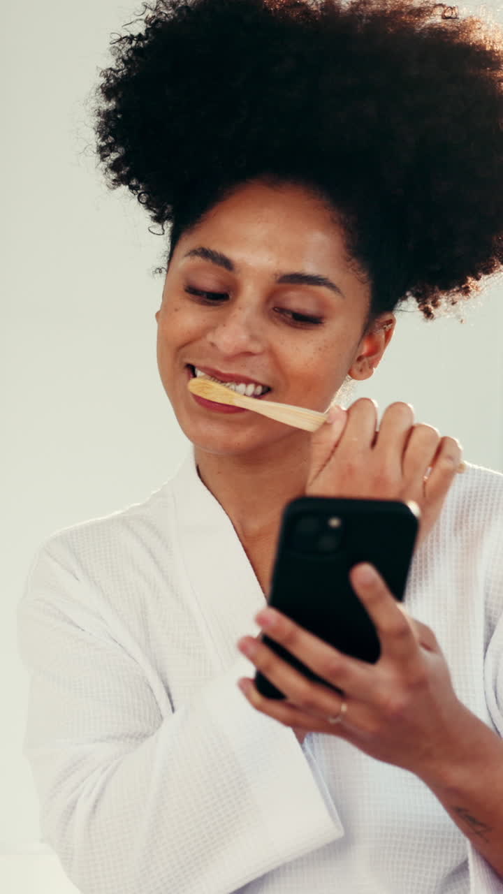Donna che si lava i denti mentre usa il cellulare