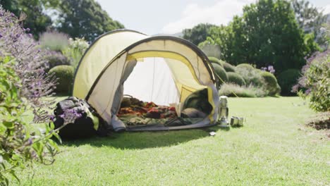 Gelbes-Zelt-Mit-Decken-Und-Kissen-über-Bäumen-Im-Sonnigen-Garten