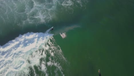 following surfer catching a wave off at guincho beach and doing some cutbacks in cascais, portugal