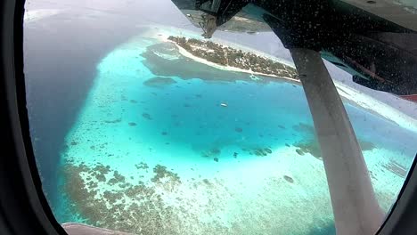 Seaplane-flying-over-a-coral-island-and-lagoon