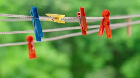 multi-colored clothespins sway in the wind on the clothesline.