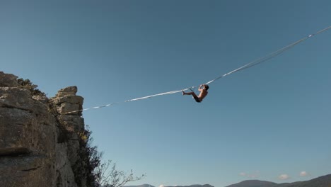 toma de cardán de hombres en un slackline en la cima de una montaña