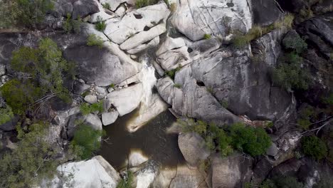 aerial over rocks, waterfall and boulders at emerald creek falls