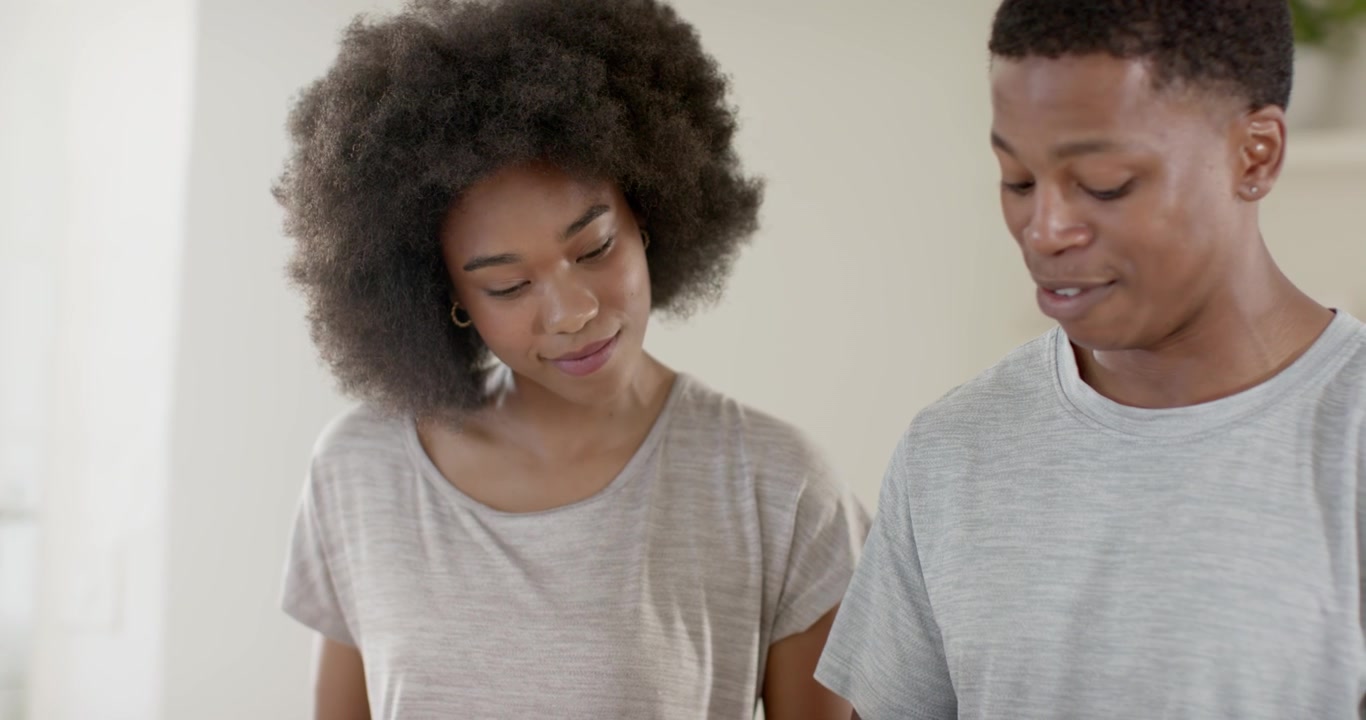 African American couple at kitchen counter he talking urging she checking item with tool smartwatch