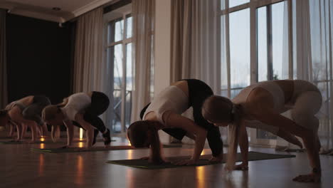 fitness-club.-Female-Caucasian-instructor-coaching-and-adjust-correct-pose-to-Caucasian-girl-student-at-front-while-others-doing-follow-them.