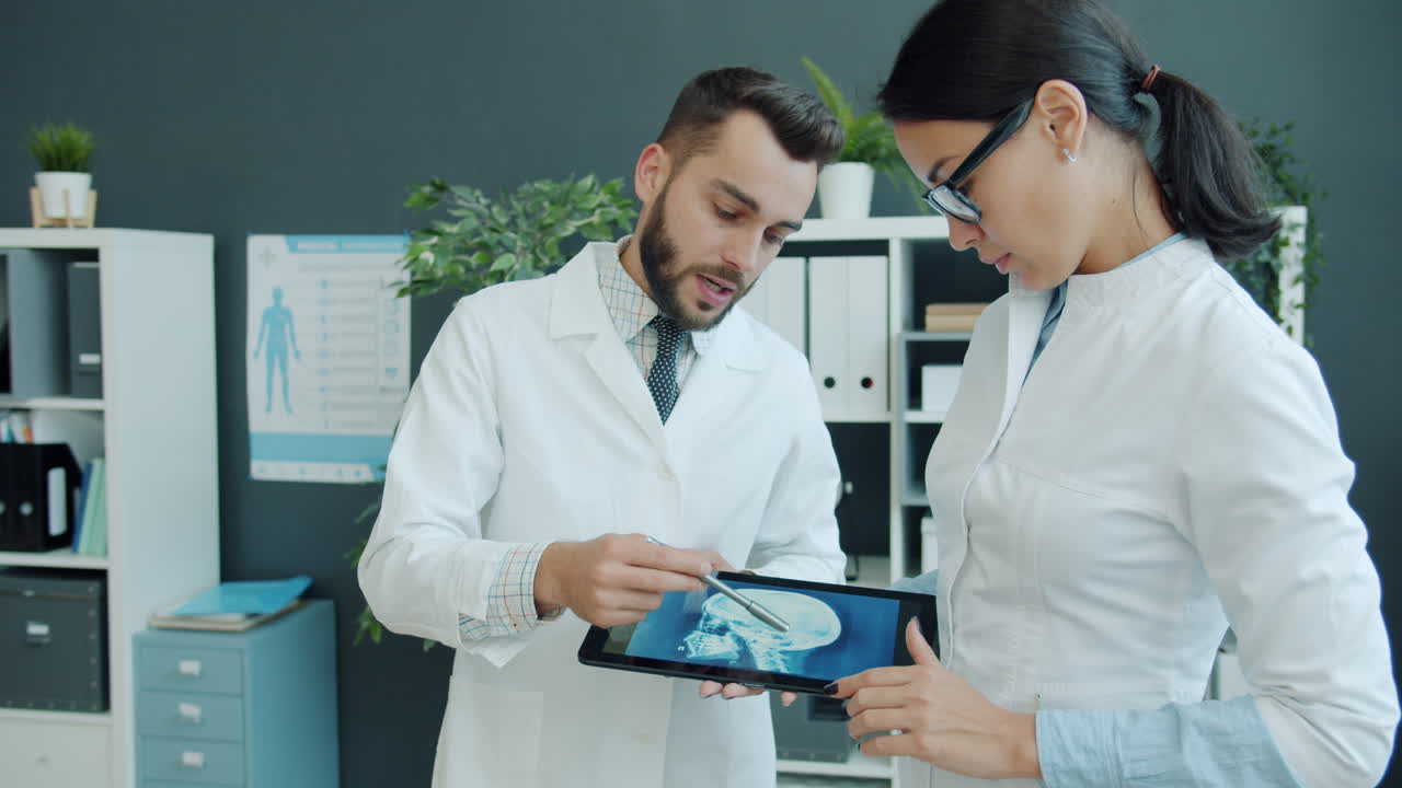 Doctors reviewing head X-ray on tablet