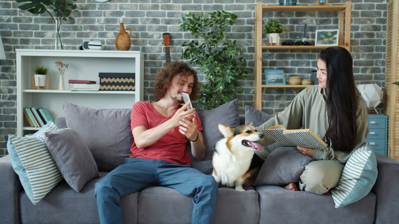 Couple relaxing on a sofa with a dog at home