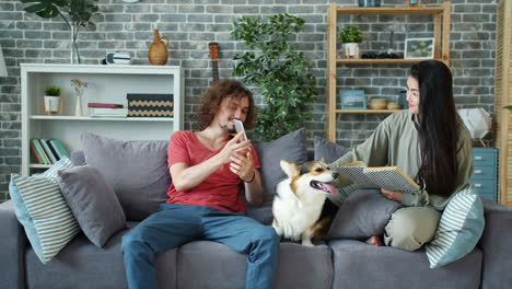 couple relaxing on a sofa with a dog at home