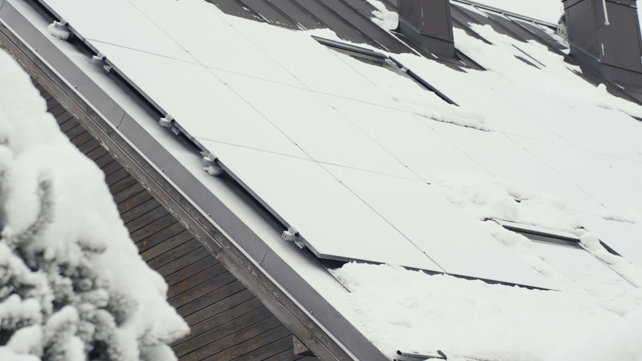 paneles solares en el techo de una casa completamente cubierta de nieve