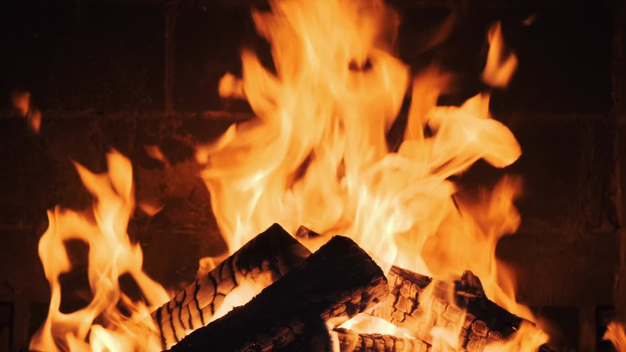 Fire in the fireplace in lobby of large resort hotel in mountains slow motion. Dry burning firewood in fireplace. Pattern of bright orange flame. Relax. Family holidays