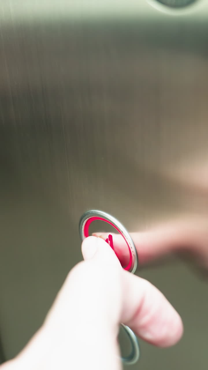 un dedo presionando el botón número cuatro dentro de un ascensor. el panel del ascensor es metálico con números de piso claramente marcados, mostrando el diseño y la funcionalidad moderna del ascensor