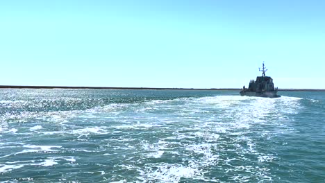 a patrol ship sails across the atlantic ocean near the algarve coastline in portugal