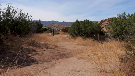 Caucasian-man-hikes-in-the-desert-southwest,-California-near-rock-formations