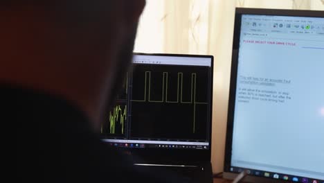 un joven caucásico rastrea los datos verdes ingresados en una computadora portátil, concepto de matlab