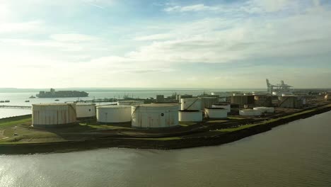 aerial : oil gas refinery industry and tankers in distance come closer as i fly by