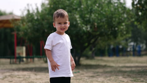 smiling toddler boy in a park