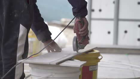 hd30 cámara lenta primer plano de azulejo de corte de trabajador con molinillo