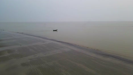 Aerial-fishing-trawler-boat-in-big-open-ocean,-leaving-coast-in-monsoon-season