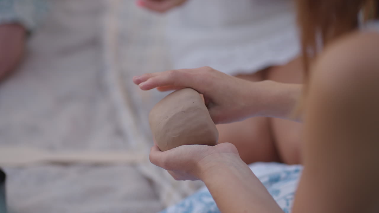 Young girls are engaged in modeling from clay in nature. Group creative classes women's group classes clay modeling training hobbies communication. Close-up.