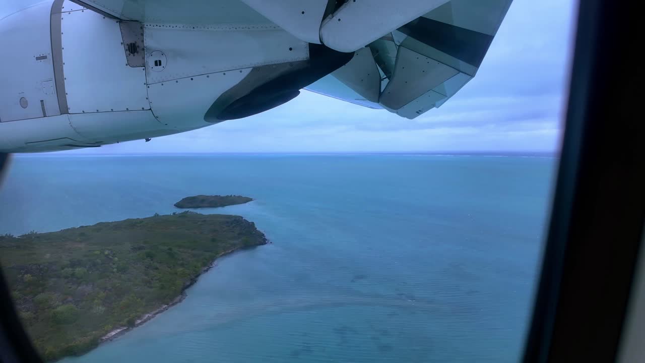 Aerial View of Ocean and Island from Airplane Window