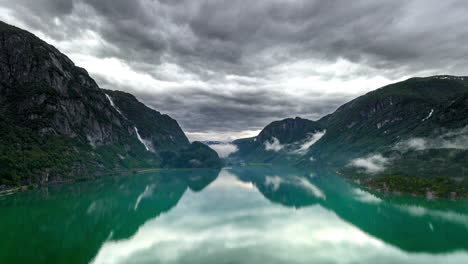 Drone-hyperlapse-over-Sandvinvatnet-lake-with-moody-clouds,-Ullensvang,-Norway