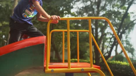 Glückliches-Kind-Auf-Dem-Spielplatz,-Das-Die-Bunte-Rutsche-Klettert-Und-Dann-Rutscht