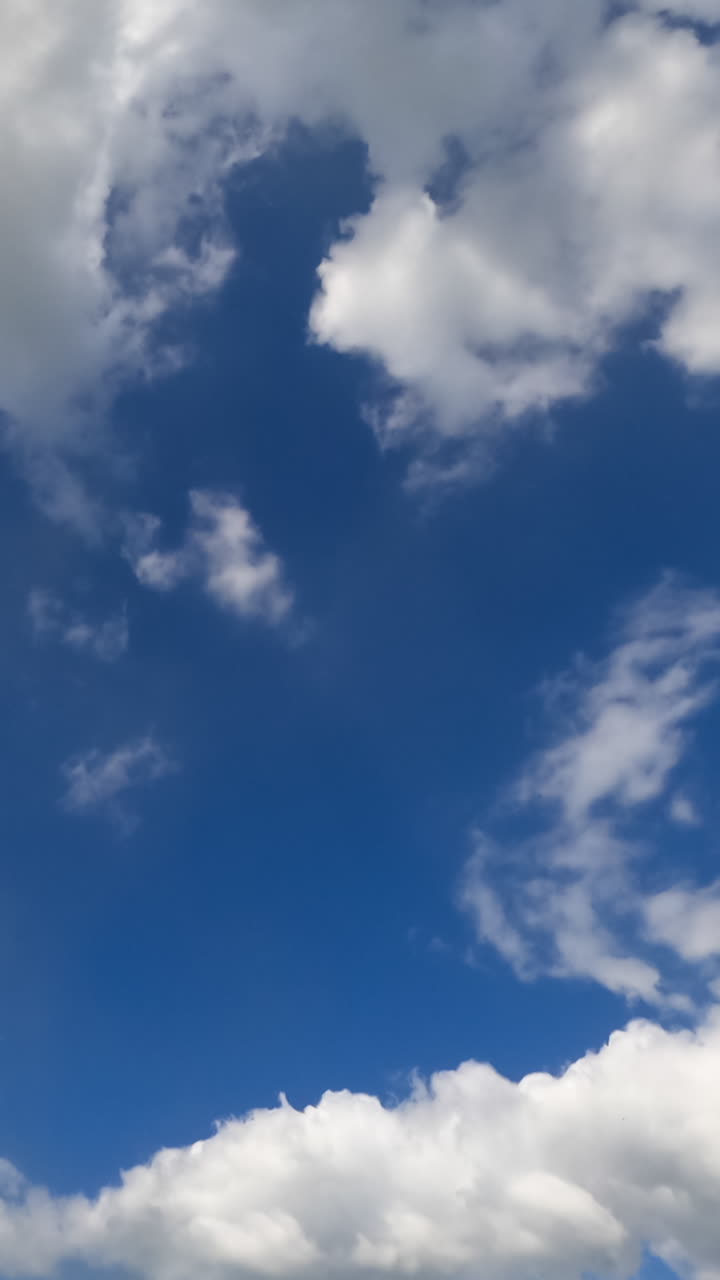 Transformation of beautiful white puffy clouds. Timelapse of amazing cloudscape moving in the sky. Vertical video