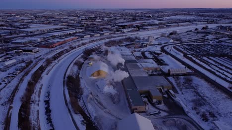 winter industrial landscape with a steaming manufacturing plant