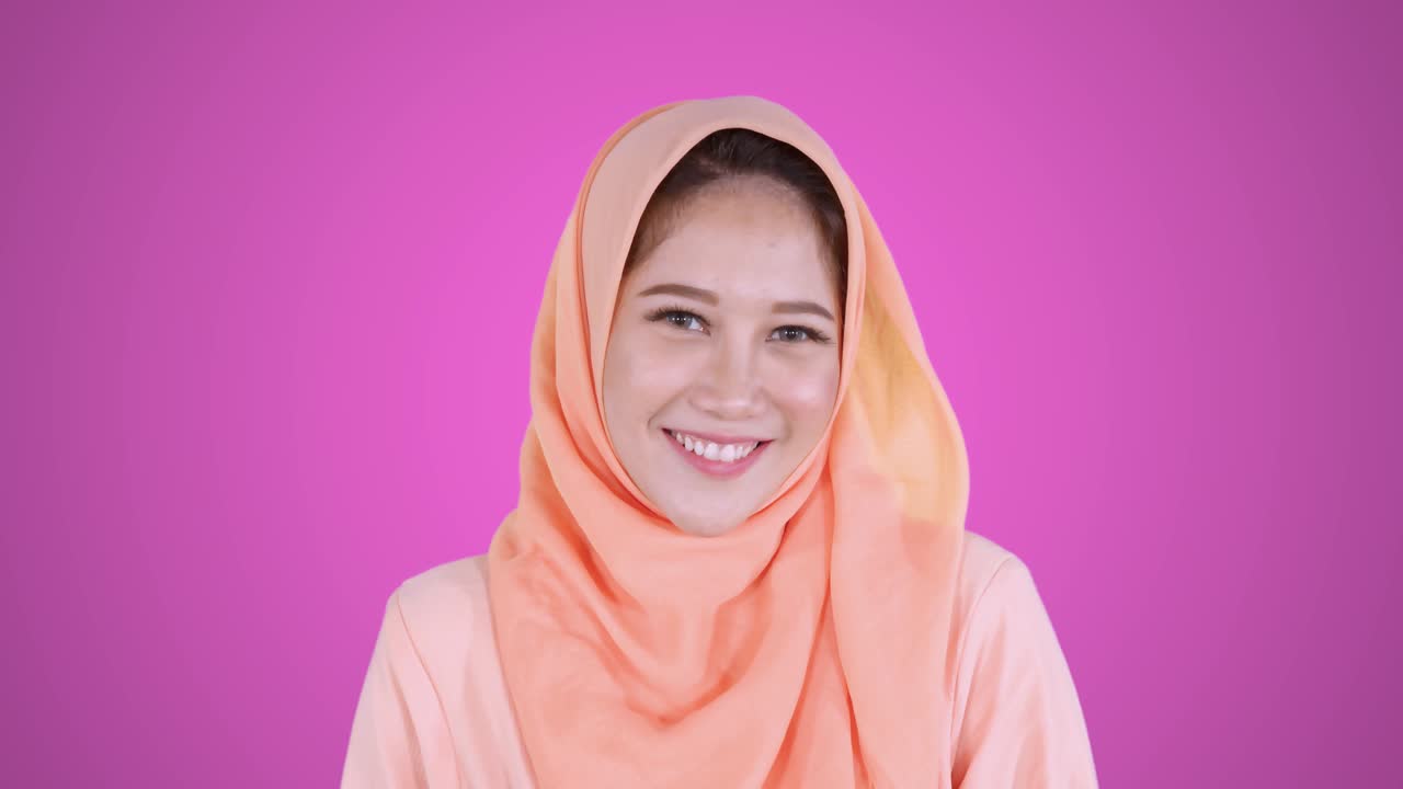 카메라를 향해 미소 짓는 아름다운 아시아 무슬림 여성