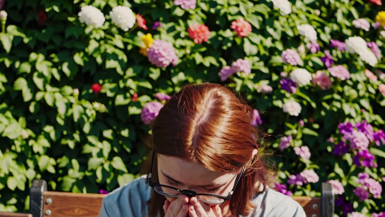 Woman sneezing outdoors