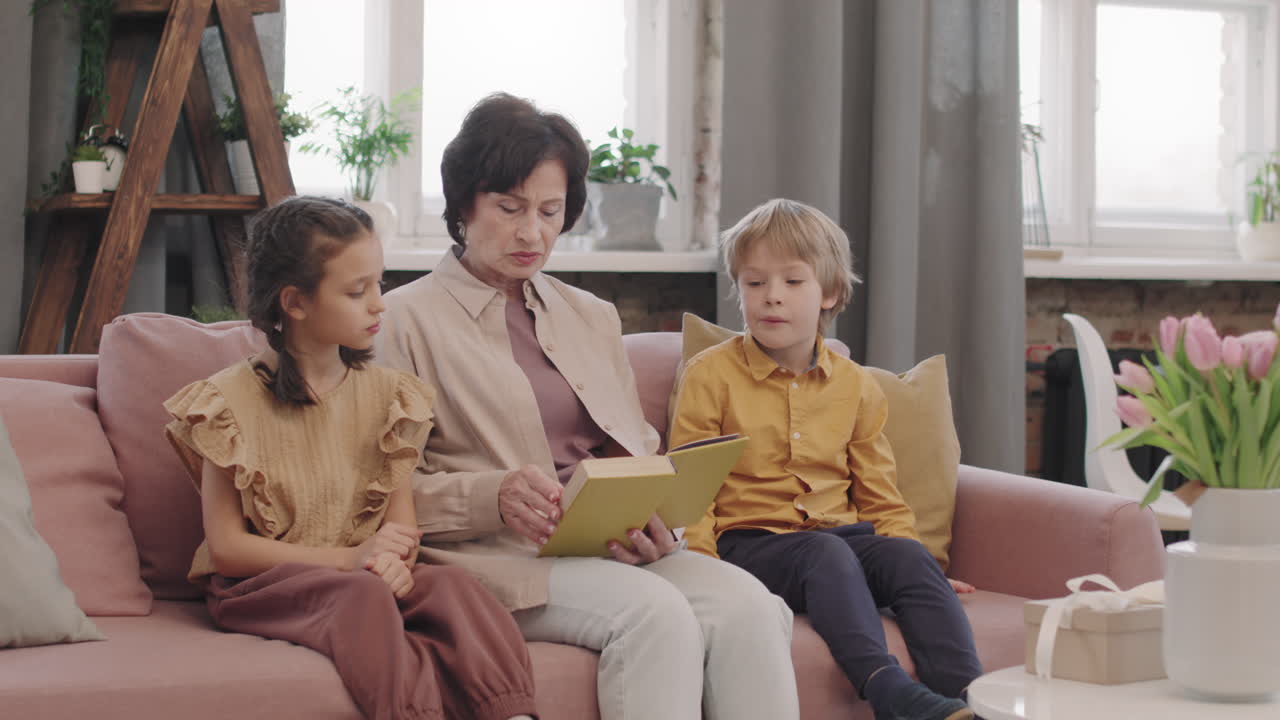 Grandmother reading a book to her grandchildren