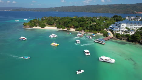 Epic-aerial-view-of-a-Caribbean-island-with-boats-and-an-impressive-beach,-Cayo-Levantado,-Dominican-Republic